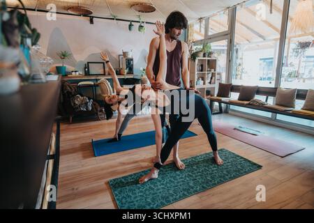 Séance de yoga en groupe guidée par un instructeur dans un environnement de studio serein Banque D'Images