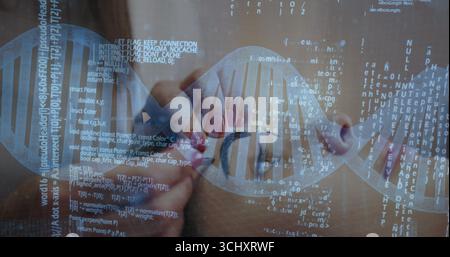 Tenant une loupe, généticien examinant l'hélice holographique d'ADN au laboratoire, avec superposition de code Banque D'Images