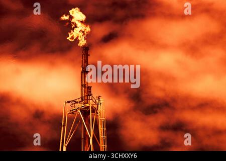 Torche, méthane gaz fumée rouge torche pour l'impact du réchauffement planétaire de l'industrie pétrolière brûlant le gaz Banque D'Images