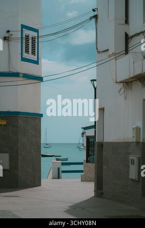 Maisons traditionnelles des Canaries avec vue sur l'océan et voiliers, style rétro look film, Fuerteventura, îles Canaries, Espagne. Banque D'Images