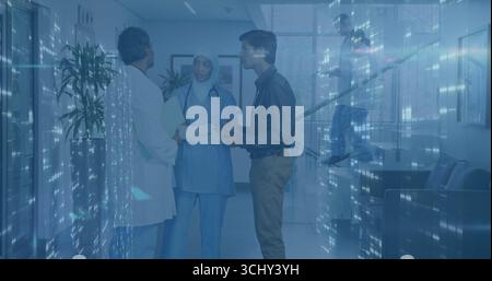 Équipe de soins discutant des documents des patients dans le couloir de l'hôpital, avec stéthoscopes et dossier Banque D'Images