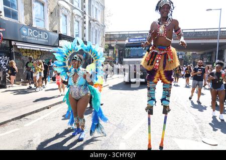 Man on pilotis mène la parade au Carnaval de Notting Hill à Londres. Banque D'Images