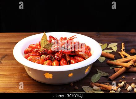 Écrevisses chinoises à treize épices dans un bol en céramique sur une table rustique Banque D'Images