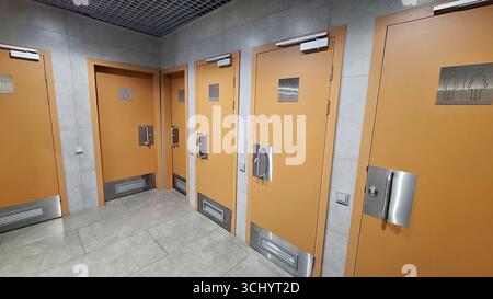 Intérieurs de toilettes publiques avec plusieurs portes de stalle au design moderne Banque D'Images