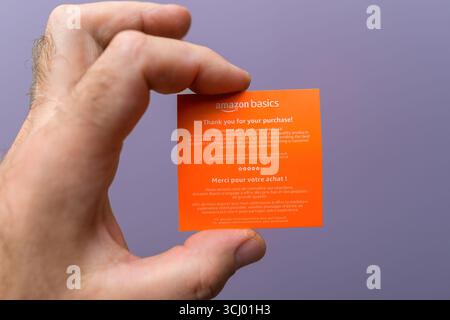 Paris, France - 21 mai 2024 : carte de remerciement Orange Amazon Basics pour achat tenue en main, avec texte en anglais et en français demandant le flux client Banque D'Images