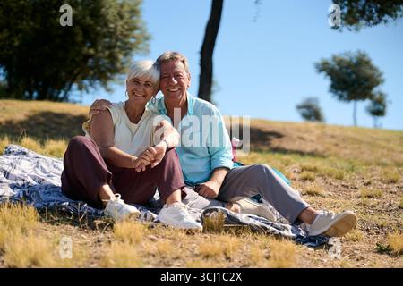 Heureux couple senior appréciant pique-nique dans la nature Banque D'Images
