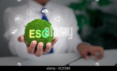 Professionnel tenant globe vert brillant avec texte ESG et icônes de durabilité, responsabilité sociale d'entreprise, investissement éthique, CA environnemental Banque D'Images