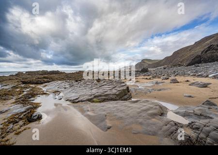 Sandymouth Beach Cornwall à marée basse avec des nuages de pluie se rassemblant Banque D'Images