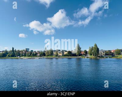 Vue panoramique sur le front de mer avec l'eau bleue et une ville pittoresque sous un ciel ensoleillé. Banque D'Images