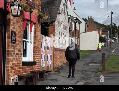 Whitwick, Leicestershire, Royaume-Uni. 4 septembre 2025. Un homme passe devant des drapeaux syndicaux suspendus à un pub à cause de la campagne politique ÒRaise The ColoursÓ. Les partisans de la campagne prétendent que c'est dans le but de promouvoir le patriotisme et que c'est non partisan, bien qu'elle ait été soutenue par plusieurs personnalités et organisations associées à l'extrême droite. Crédit Darren Staples/Alamy Live News. Banque D'Images