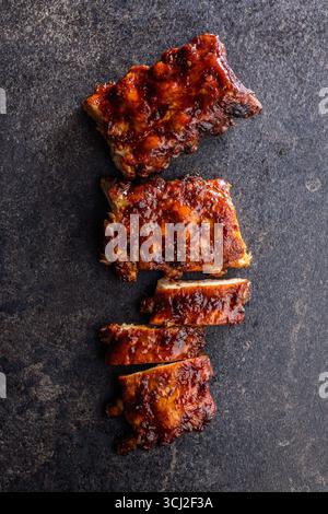 Côtes glacées BBQ de porc sur une table noire. Vue de dessus. Banque D'Images