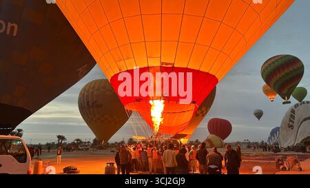 Louxor, Égypte - 10 février 2025 : les montgolfières se remplissent d'air à l'aube en préparation d'un vol au lever du soleil au-dessus de Louxor, Égypte. Banque D'Images