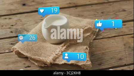Montrant pichet en céramique blanche tenant le lait sur le tissu de toile de jute sur la table, avec des icônes de médias sociaux. Rustique, ferme, culinaire, naturel, confortable, vintage, Banque D'Images