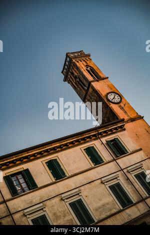 Un beau gros plan d'une tour de l'horloge dans le centre de Pietrasanta, Toscane. L'image met en évidence les détails complexes de la façade en pierre et du cl Banque D'Images