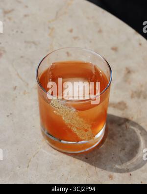 Cette image capture un cocktail élégant et riche en couleurs dans une lumière vive et naturelle, parfait pour les menus de bar, les blogs de style de vie sophistiqués, ou le whisky Banque D'Images