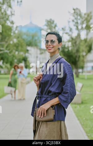 Portrait de jeune femme adulte souriant en plein air dans Urban Park Banque D'Images