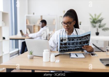 Médecin femme analysant les radiographies au cabinet médical moderne Banque D'Images