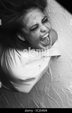 Hurlant femme folle en camisole de force, monochrome Banque D'Images