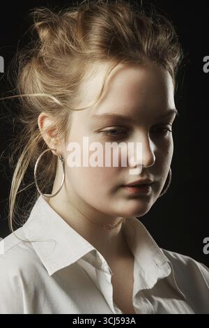 Jeune femme belle triste regardant loin sur fond noir Banque D'Images