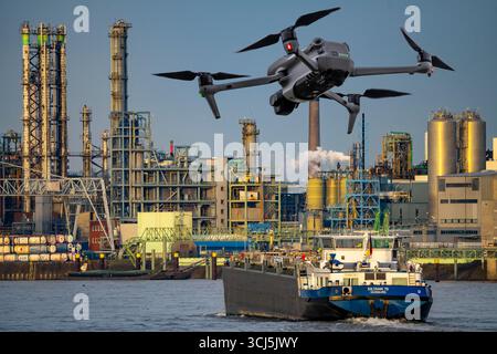 Image symbolique, photomontage, reconnaissance, espionnage avec des drones dans des installations industrielles, infrastructure critique, drone volant vers un industriel Banque D'Images
