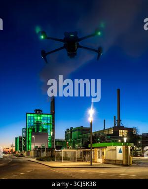 Image symbolique, photomontage, reconnaissance, espionnage avec des drones dans des installations industrielles, infrastructure critique, drone volant vers un industriel Banque D'Images