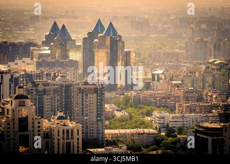 Vue panoramique d'Almaty, Kazakhstan, vu de la montagne Kok-Tobe au coucher du soleil, avec ses gratte-ciel futuristes reflétant dans le soleil du soir Banque D'Images