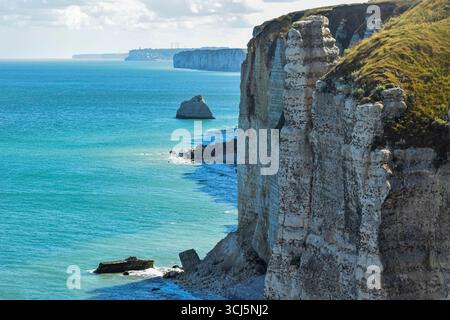 Vue estivale époustouflante depuis les falaises d'Etretat en Normandie, avec les eaux turquoises de la Manche, les vagues superposées et les majestueuses falaises en ivoire couronnées de verdure - une merveille naturelle inoubliable. Banque D'Images