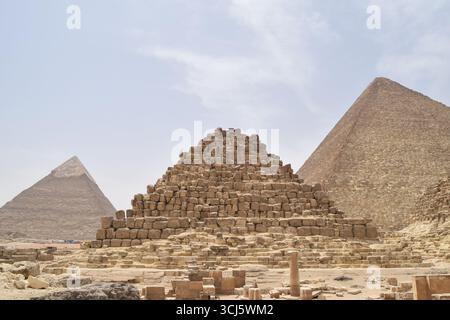Pyramides de Gizeh au Caire, Egypte, avec la pyramide de Menkaure devant et les pyramides plus grandes de Khafre et Khoufou s'élevant derrière sous un ciel désertique Banque D'Images
