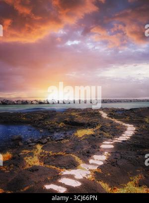 Chemin de pierre et coucher de soleil. Plage de Onekahakaha. Hawaï, la Grande île., Banque D'Images