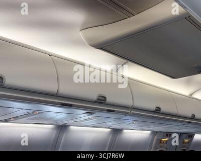 Compartiments à bagages supérieurs et plafond de cabine à l'intérieur d'un avion de passagers. Voyage, aviation, et la conception pratique de l'espace dans les avions modernes Banque D'Images