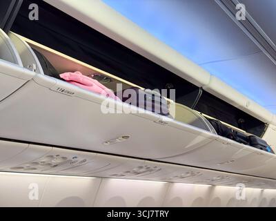 Compartiments à bagages supérieurs et plafond de cabine à l'intérieur d'un avion de passagers. Voyage, aviation, et la conception pratique de l'espace dans les avions modernes Banque D'Images