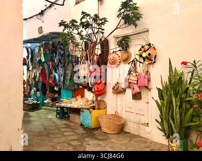 Des articles faits à la main se dressent dans le souk de Tanger, au Maroc, avec des sacs colorés, des chapeaux de paille et des paniers tissés. Capturé le 2 octobre 2024 Banque D'Images