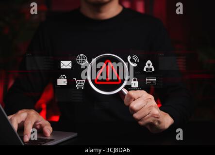 Alerte d'escroquerie en ligne et concept de détection de fraude. La personne tient la loupe en se concentrant sur le symbole d'avertissement rouge, la détection d'escroquerie en ligne, le risque de cyberfraude, Banque D'Images
