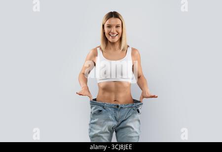 Femme blonde gaie portant un pantalon et souriant Banque D'Images