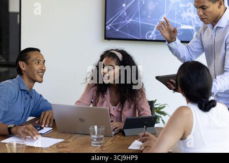 Collaboration à table de bureau, équipe commerciale discutant des idées avec des ordinateurs portables et des tablettes Banque D'Images