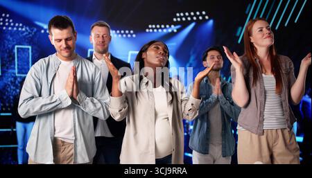 Groupe multiracial priant ensemble dans l'intérieur de l'église afro-américaine. Banque D'Images