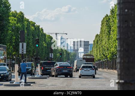 Paris, France. 14 mai 2025, circulation sur l'avenue des champs-Elysées avec Arc de Triomphe en arrière-plan à Paris Banque D'Images