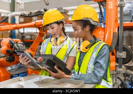 formation d'ingénieur robotique, travail de technicien dans l'opérateur de contrôle de machine de bras de soudage de robot industriel moderne d'usine Banque D'Images