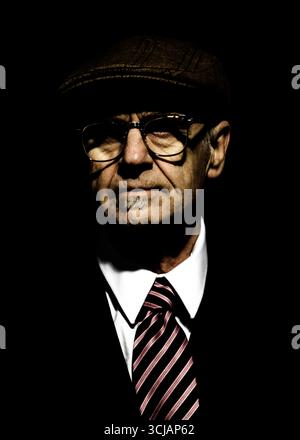 Portrait d'un homme portant un chapeau, des lunettes, un costume et une cravate. Banque D'Images