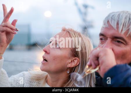 Un couple plus âgé partage un moment joyeux sur un bateau, regardant le ciel, entouré par la nature, incarnant l'élégance et la beauté de la vie dans un cadre tranquille Banque D'Images