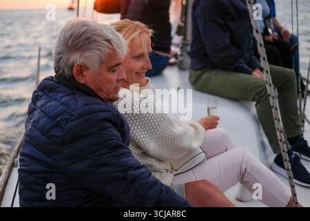 Couple plus âgé partage un moment joyeux tout en naviguant sur des eaux calmes, exsudant l'élégance et le bonheur, entouré par la beauté de la nature et la soirée l Banque D'Images