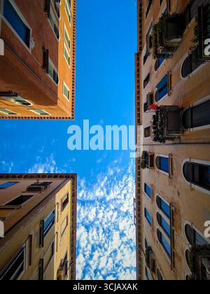 Une vue à couper le souffle en bas angle regardant les façades classiques et étroites des bâtiments historiques à Venise, en Italie. L'image capture le « canyon » unique Banque D'Images