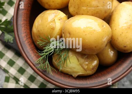 Savoureuses pommes de terre jeunes bouillies avec aneth dans un bol sur une table grise, vue de dessus Banque D'Images