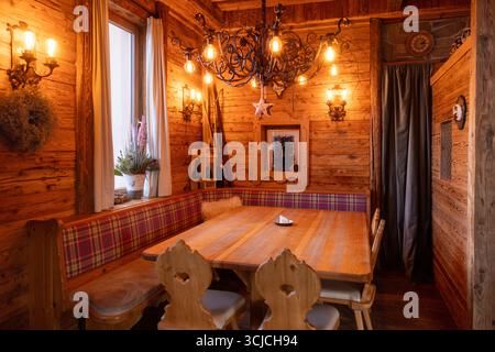 L'intérieur chaleureux et accueillant d'un restaurant alpin autrichien présente un décor traditionnel en bois, un éclairage tamisé et un style rustique. Parfait pour un wi Banque D'Images