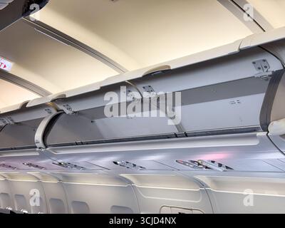 Compartiments à bagages supérieurs et plafond de cabine à l'intérieur d'un avion de passagers. Voyage, aviation, et la conception pratique de l'espace dans les avions modernes Banque D'Images