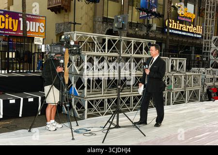HOLLYWOOD, CALIFORNIE, États-Unis : George Pennacchio (R), journaliste de divertissement ABC7, fait un stand-up en direct pendant les préparatifs de la 87e cérémonie annuelle des Academy Awards® sur Hollywood Boulevard, devant le Dolby Theatre à Hollywood, Californie, le 18 février 2015. © Lee Roth / Roth Stock Archives Banque D'Images