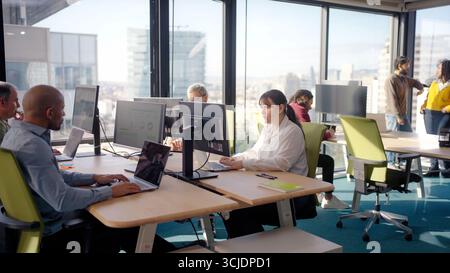 Collègues travaillant avec des ordinateurs dans un bureau moderne Banque D'Images