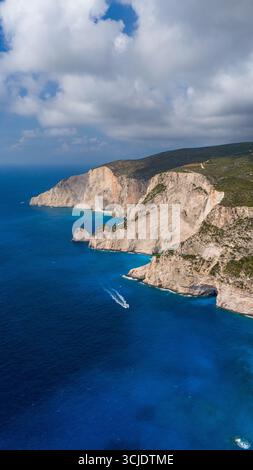 Vue imprenable sur les falaises blanches de Zakynthos Grèce s'élevant de la mer Ionienne turquoise avec route côtière sinueuse et collines verdoyantes au-dessus Banque D'Images