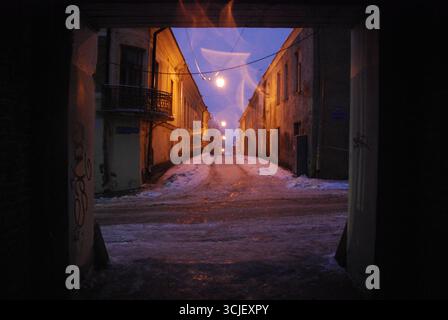 Vyborg, Russie - 02 janvier 2013 - mystérieuse ruelle enneigée la nuit avec des lampadaires chauds et des bâtiments historiques. Banque D'Images