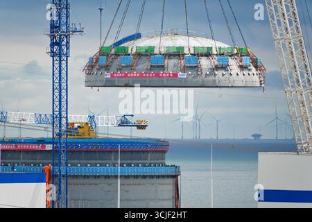 YANTAI, CHINE - 6 SEPTEMBRE 2025 - une grosse grue soulève la tête supérieure de la coque de sécurité de l'île nucléaire de l'unité 4 à la centrale nucléaire de Haiyang à Yantai, Shandong, Chine, le 6 septembre 2025. Banque D'Images